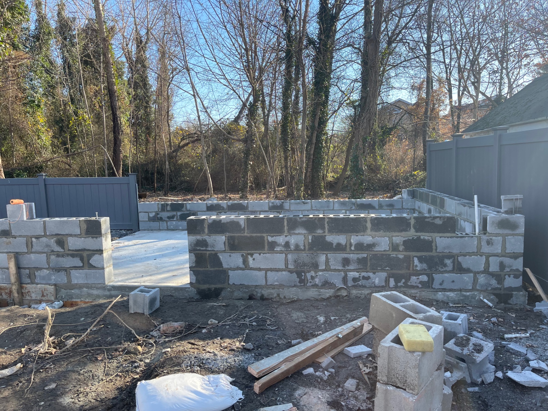 Cinder block knee-wall foundation laid around finished concrete pad for backyard cabin build