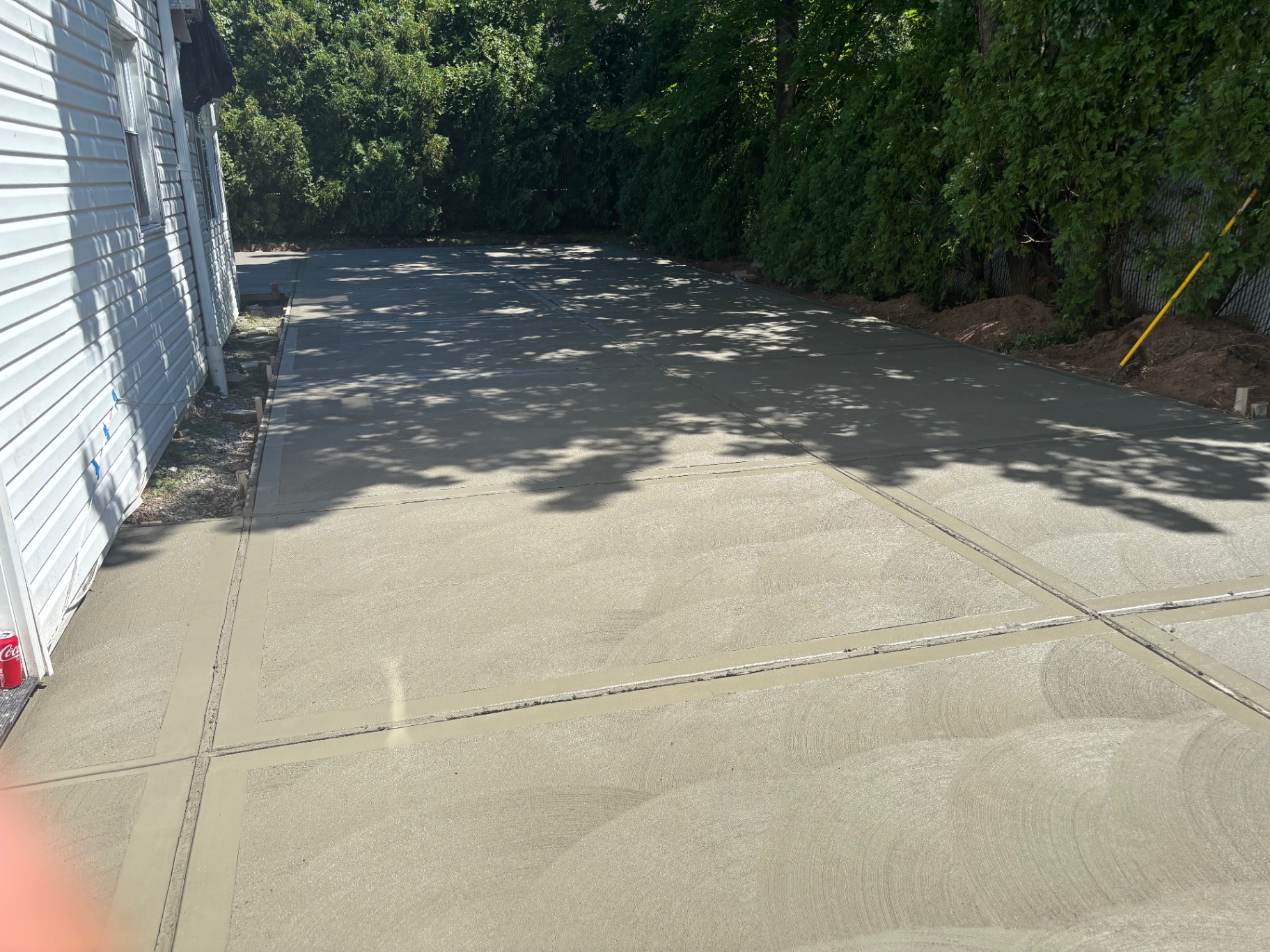 Finished broom-finished concrete driveway alongside Staten Island home