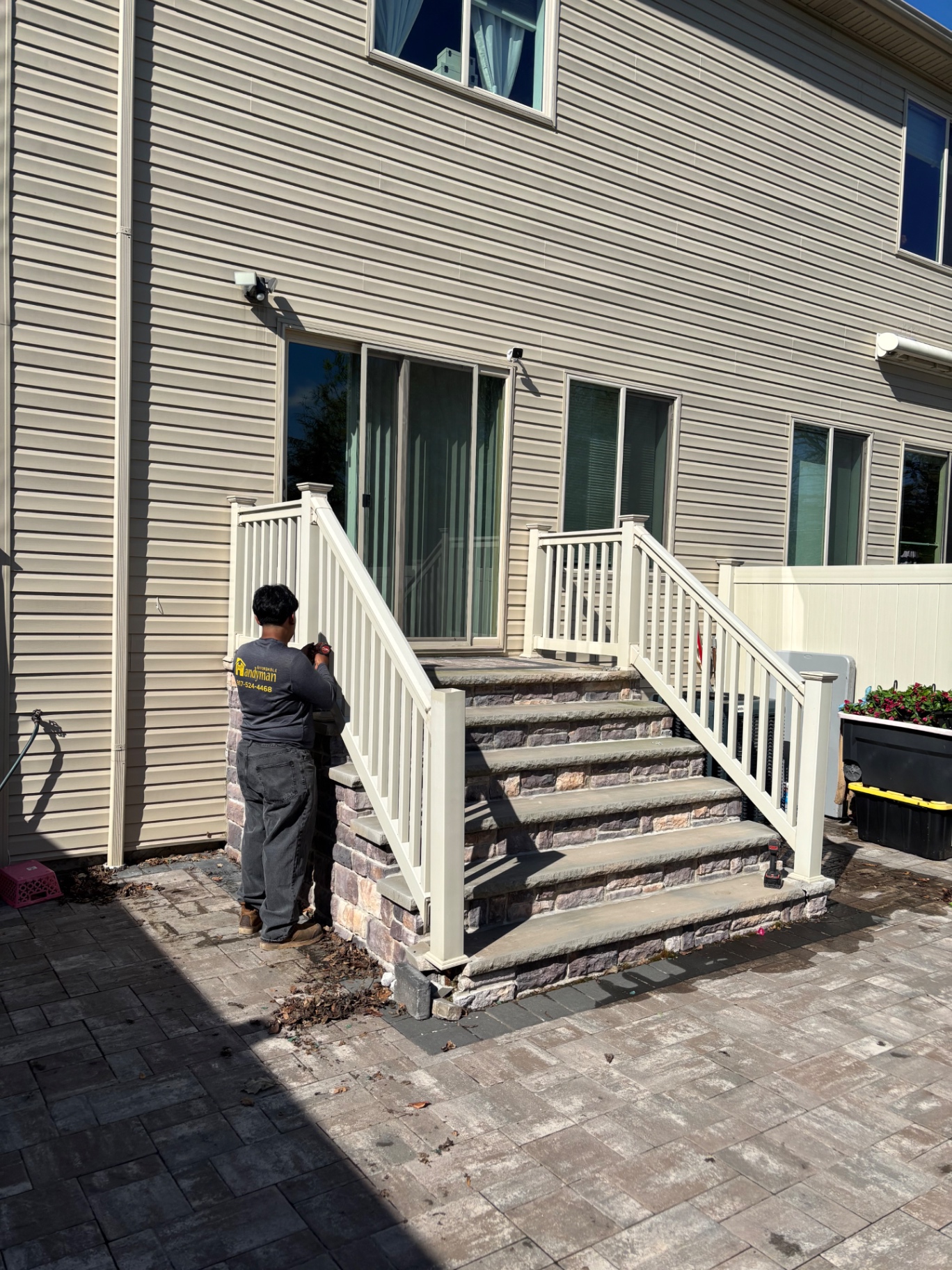 Original stone-veneer steps with white vinyl railings before deck rebuild