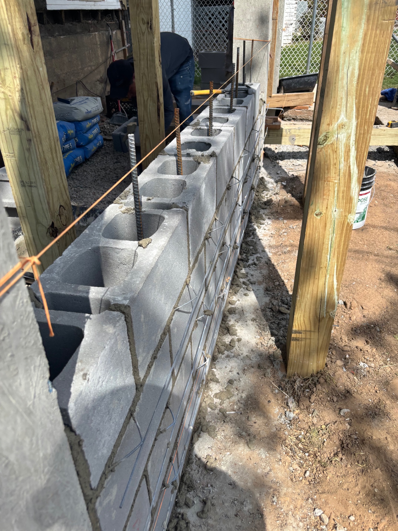 Reinforced cinder block foundation with rebar being built for new front porch structure