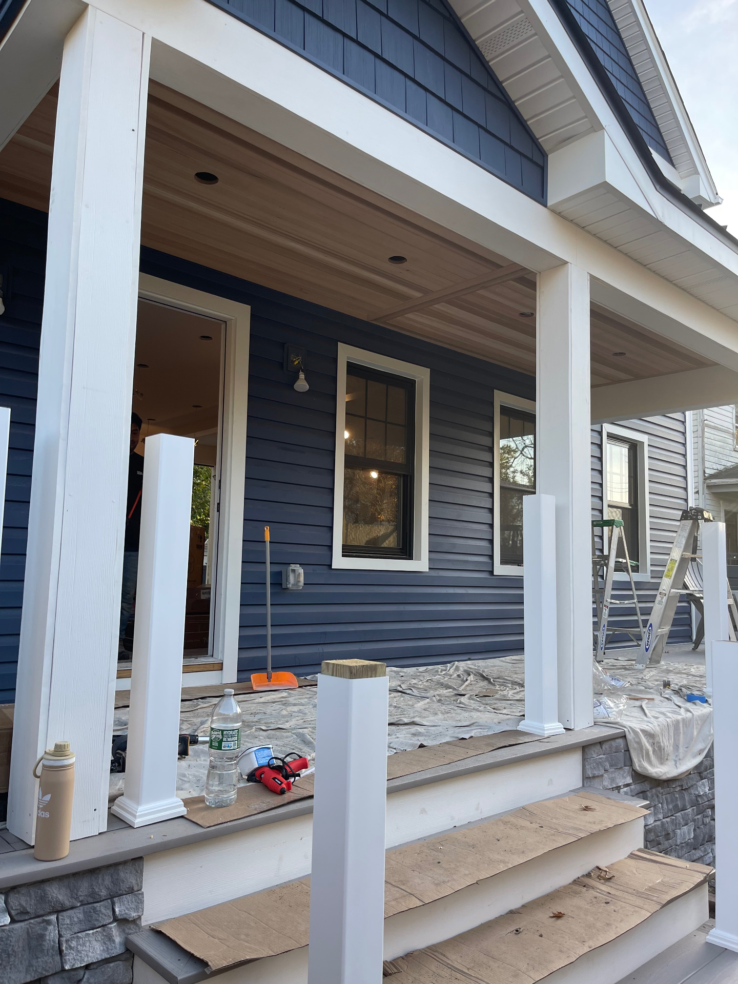 Exterior front porch view showing columns, trim, and ceiling nearing completion