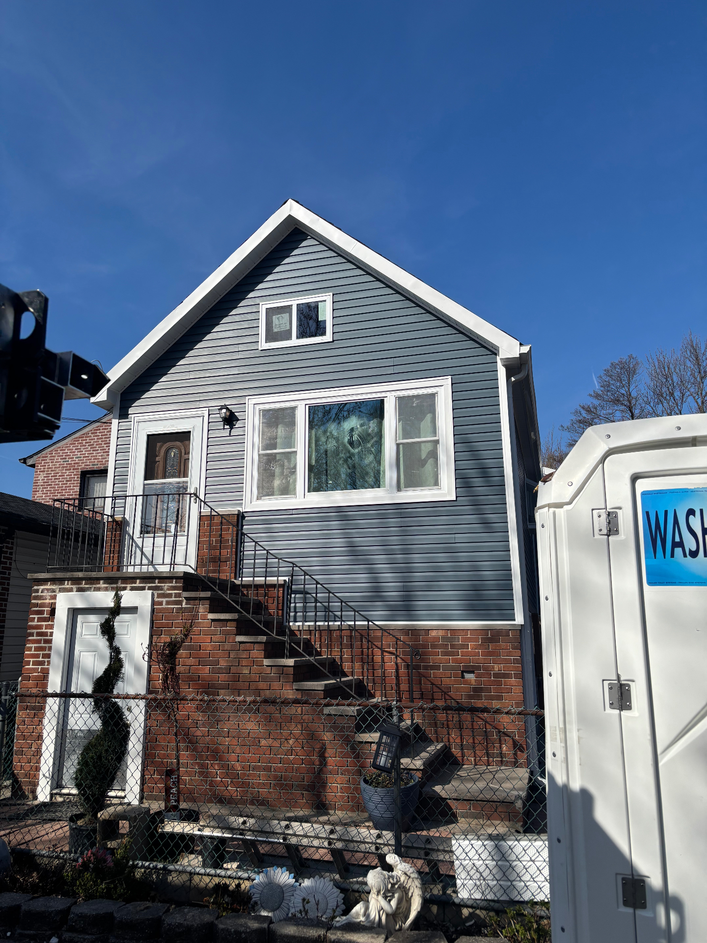 Same Staten Island home after new slate blue vinyl siding and white trim installation